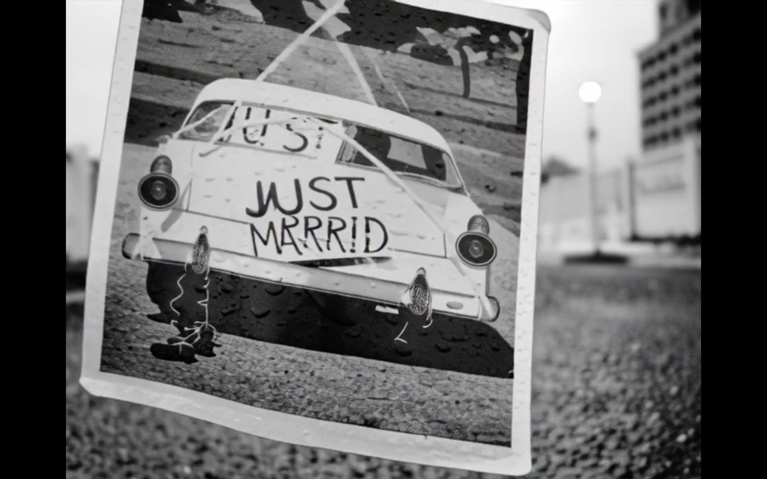 Voiture des mariés en noir et blanc avec décoration Just Married